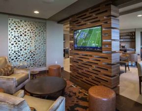 Lobby workspace with TV screen at the Hilton Dallas Plano Granite Park.