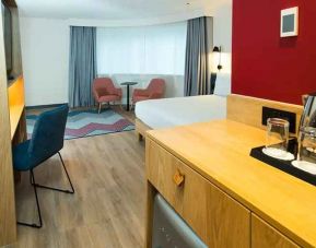 spacious king room with work desk, lounge area, TV, and coffeee stand at Hampton by Hilton London Park Royal.