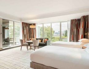 Twin room with large windows and desk at the Hilton Amsterdam.
