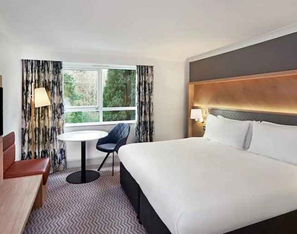 spacious king room with TV, comfortable work desk and natural light at Hilton Cobham.
