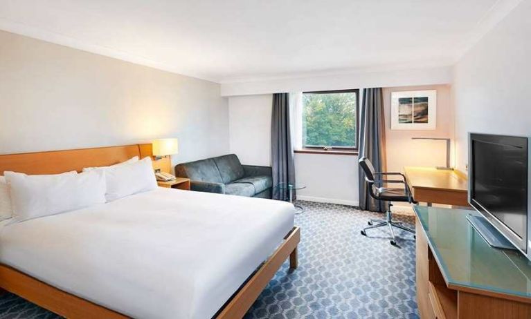 Spacious king room with TV, comfortable work desk and natural light at Hilton London Watford.
