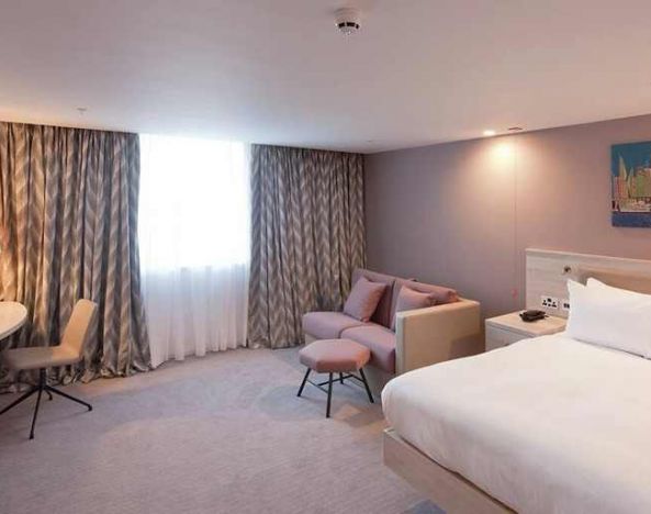 spacious king room with TV, work desk, and lounger at Hampton by Hilton Leeds City Centre.