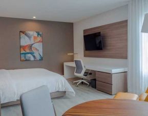 luxurious king suite with TV, work desk, and dining area at Hilton Garden Inn Santa Ana San Jose.