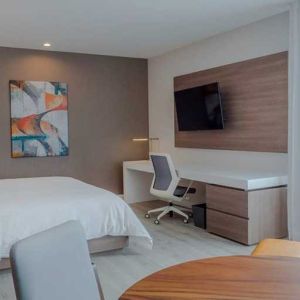 luxurious king suite with TV, work desk, and dining area at Hilton Garden Inn Santa Ana San Jose.