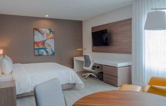 luxurious king suite with TV, work desk, and dining area at Hilton Garden Inn Santa Ana San Jose.