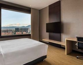 comfortable king room with TV, work desk, and natural light at DoubleTree by Hilton Bogota Salitre AR.