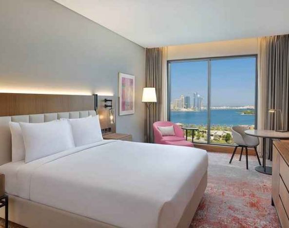 beautiful king room with work desk, TV, and water/city views at DoubleTree by Hilton Sharjah Waterfront Hotel & Residences.