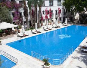 beautiful outdoor pool surrounded by seating and sun beds at DoubleTree by Hilton Bodrum Marina Vista.