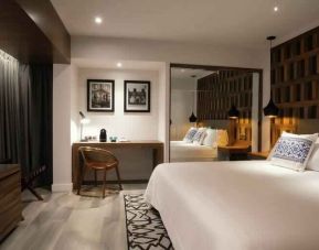 King bedroom with desk and TV screen at the Hotel 1970 Guadalajara, Curio Collection by Hilton.