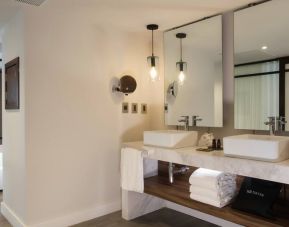 Bathroom with two sinks and mirrors at the Hotel 1970 Guadalajara, Curio Collection by Hilton.