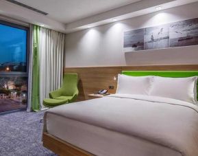 comfortable king bed with work desk and large windows at Hampton by Hilton Istanbul Zeytinburnu.