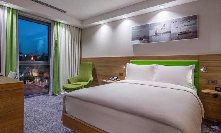 comfortable king bed with work desk and large windows at Hampton by Hilton Istanbul Zeytinburnu.
