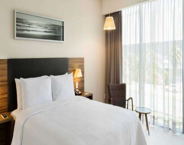 Bright queen room with window at the Hampton Inn by Hilton Cancun Cumbres.