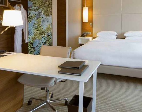 luxurious king suite with business desk ideal for working remotely at Hilton Barcelona.