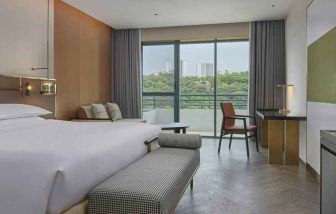 spacious king bedroom with desk, chair, and lounge suite at Hilton Guangzhou Science City.