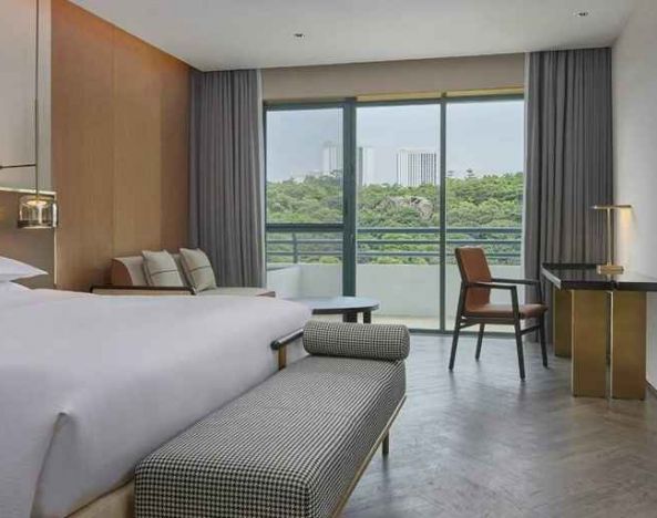 spacious king bedroom with desk, chair, and lounge suite at Hilton Guangzhou Science City.