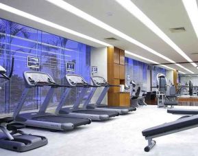 well equipped fitness center with treadmills, bikes, and weights at Hilton Guangzhou Science City.