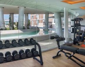 Fitness center with weights and machines at the Hilton Garden Inn Cancun Airport.