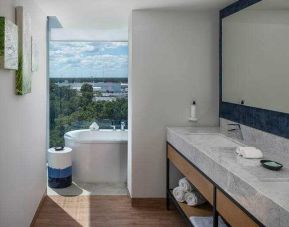 Bathroom with bath tub overlooking the airport at the Hilton Garden Inn Cancun Airport.