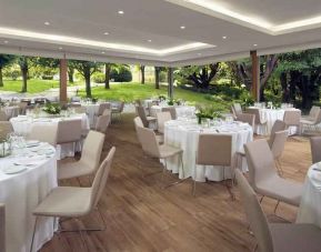 Dining area set in a beautful garden at the Boeira Garden Hotel Porto Gaia, Curio Collection by Hilton.