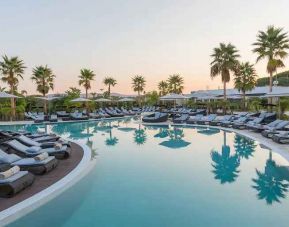 Outdoor pool with lounges at the Conrad Algarve.