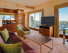 Spacious living room with view, working station and sofa at the Hilton Warsaw City.