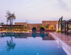 stunning outdoor pool with sun beds and seating area at Adana HiltonSA.