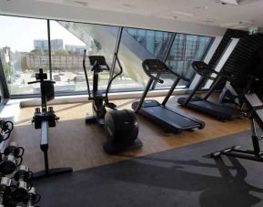 Fitness center with weights and machines at the Hampton by Hilton Olsztyn.