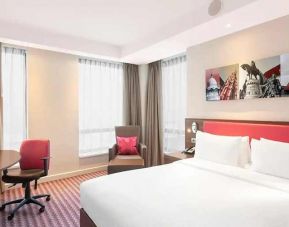 comfortable king rooom with chair, desk, TV, and couch at Hampton by Hilton Cluj-Napoca.