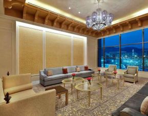 Seating area with large window and view at the Hilton Makkah Convention Hotel.