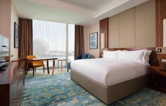 spacious king room with business desk, chair, TV, and couch at Hilton Astana.