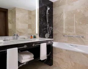 clean and spacious king bathroom with bath and shower at Hilton Astana.