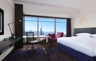 spacious king room with TV, work desk, chair, and couch at Hilton Fukuoka Sea Hawk.