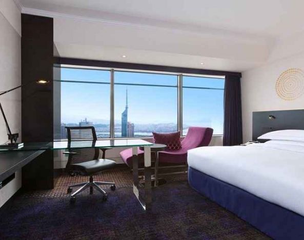 spacious king room with TV, work desk, chair, and couch at Hilton Fukuoka Sea Hawk.