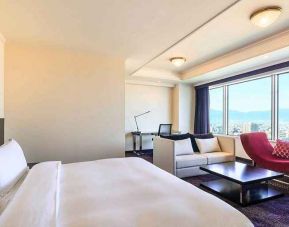 luxurious king suite with lounge area, business desk, and chair at Hilton Fukuoka Sea Hawk.