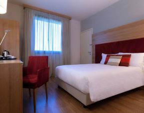 delux king room with TV, desk, and chair at Hilton Garden Inn Milan Malpensa.