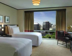 Twin room with TV screen and desk at the Conrad Bangkok.