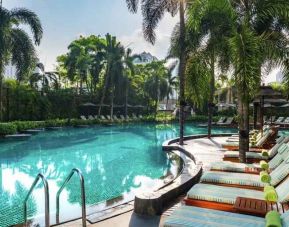 Beautiful outdoor pool with lounges at the Conrad Bangkok.