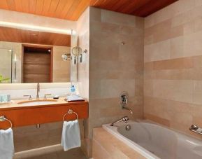 clean and spacious bathroom with bath at Hilton Kuwait Resort.