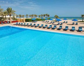 stunning outdoor pool with sunbeds at Hilton Kuwait Resort.