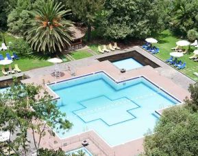 stunning outdoor pool with sun beds and umbrellas at Hilton Addis Ababa.