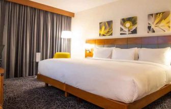 delux king room with couch, chair, and work desk at Hilton Garden Inn Nairobi Airport.