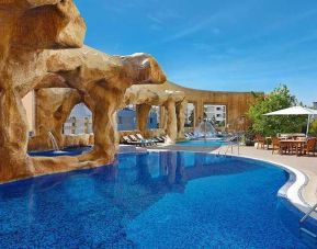 stunning outdoor pool surrounded by sun beds and seating area at Hilton Beirut Habtoor Grand.