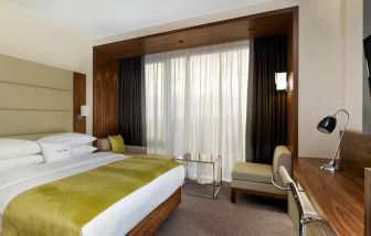 spacious king suite with TV, work desk, chair, and lounge area at DoubleTree by Hilton Zagreb.