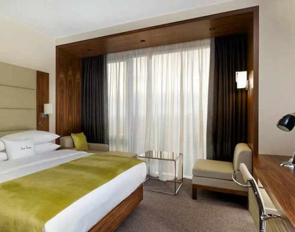 spacious king suite with TV, work desk, chair, and lounge area at DoubleTree by Hilton Zagreb.