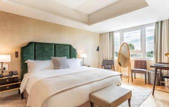 spacious king room with chair and desk and lots of natural light at Hilton Nicosia.