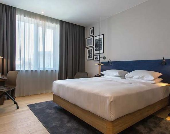 spacious king room with TV, work desk, and chair at Hilton Garden Inn Zagreb - Radnicka.