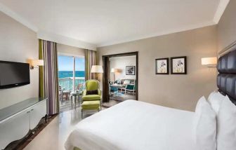 luxurious king room with TV, outdoor terrace, and sea views at Hilton Alexandria Corniche.