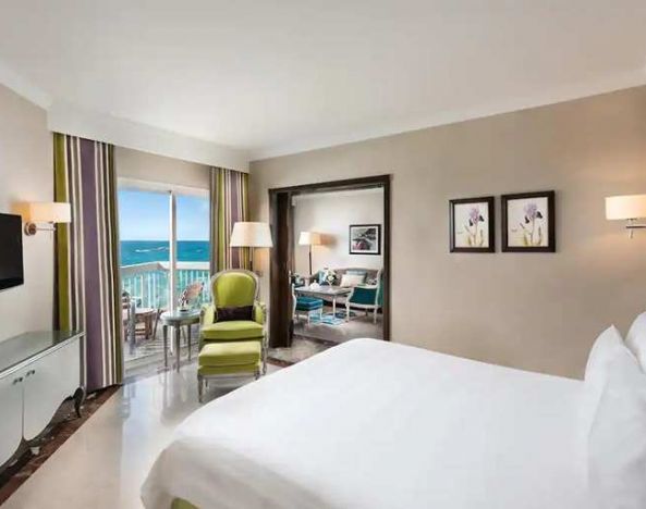 luxurious king room with TV, outdoor terrace, and sea views at Hilton Alexandria Corniche.