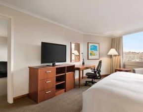 spacious king suite with TV, desk, chair, and couch at Hilton Colon Quito.